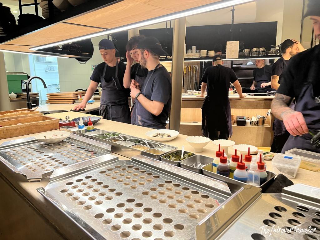 Open kitchen at a fine dining seafood restaurant in Rimini, chefs preparing mise en place