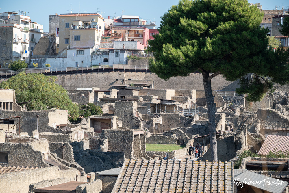 Aerial view of Herculaneum excavations with ancient ruins below modern Ercolano buildings