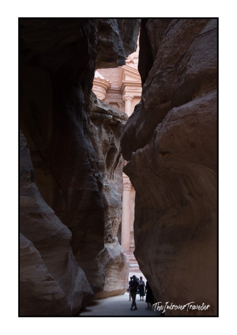 Tourists walking through the Siq canyon toward Al-Khazneh Treasury facade, Petra, Jordan