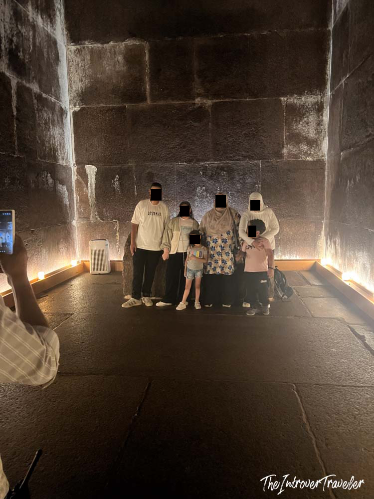 Tourists posing for a photo inside the dimly lit burial chamber of the Great Pyramid of Giza