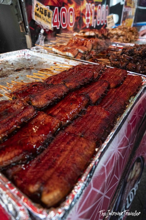 Glazed unagi skewers on sale at a Tsukiji fish market street food stall, priced at 400 yen
