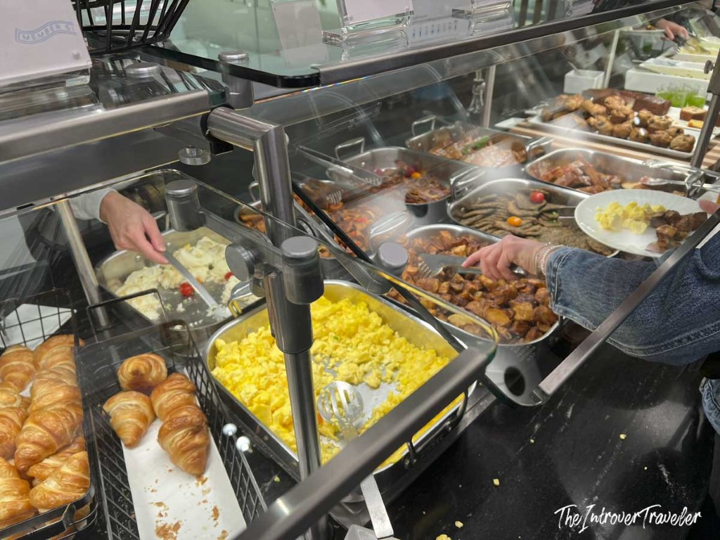Hot breakfast buffet at Centurion Lounge LGA, with scrambled eggs, croissants, and roasted meats