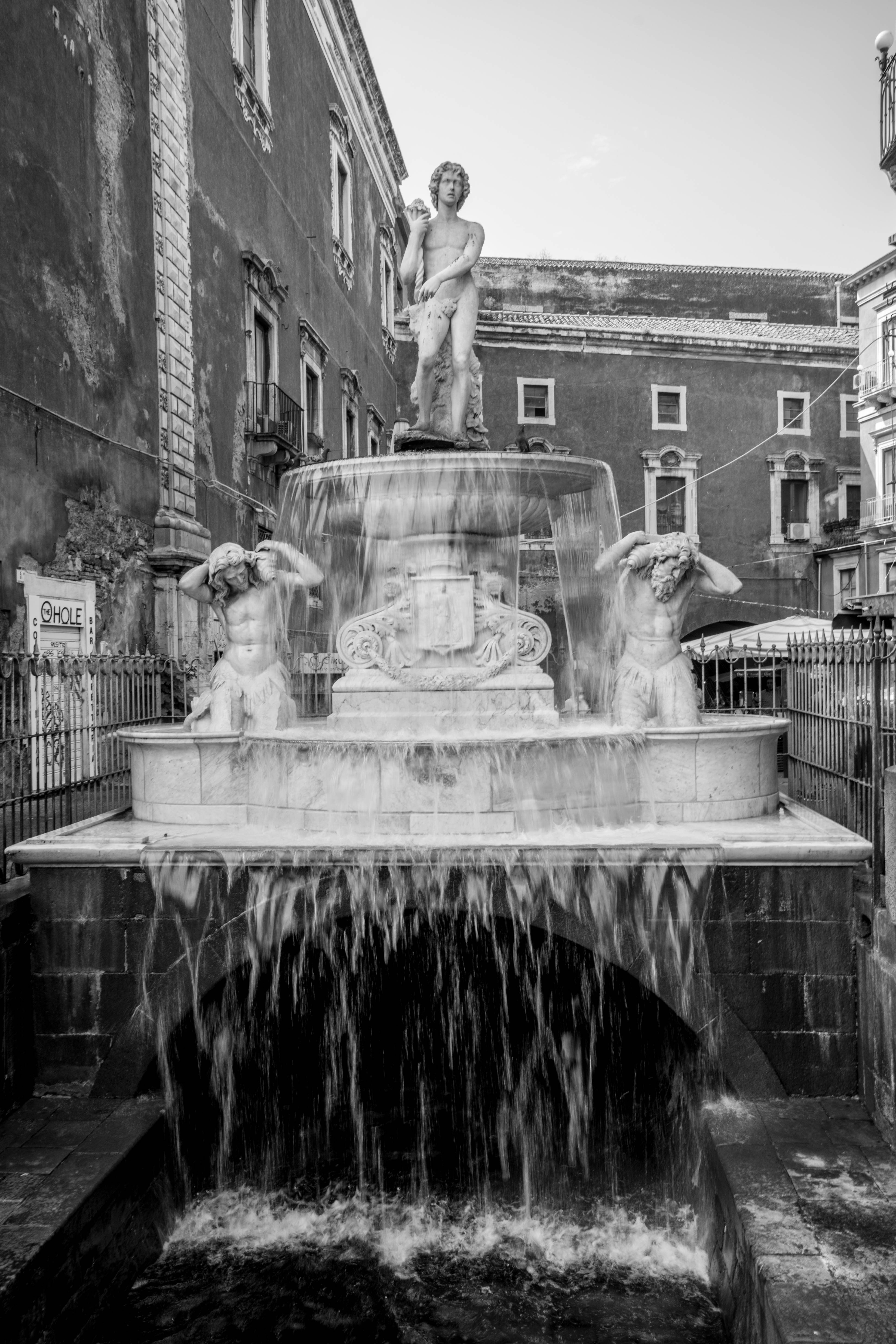 Amenano Fountain in Catania, Sicily, with cascading water and classical sculptures in baroque style
