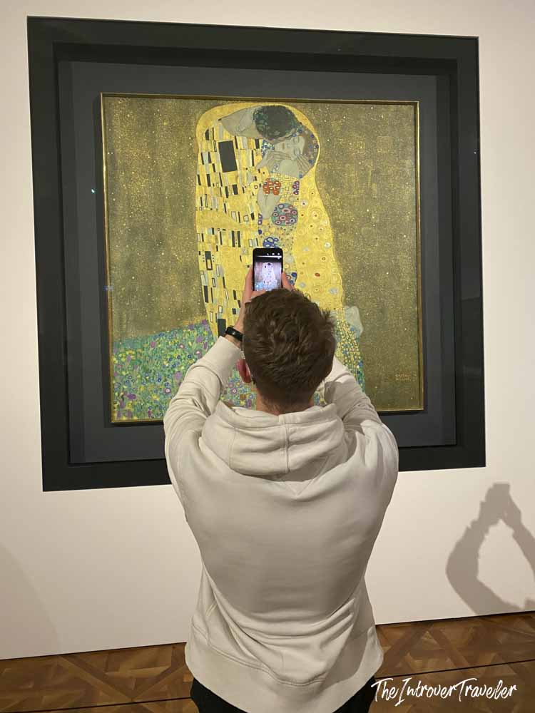 Visitor photographing The Kiss by Gustav Klimt at the Belvedere Museum in Vienna