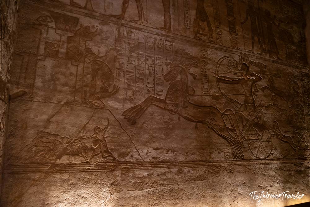 Battle relief carving inside Abu Simbel showing Ramesses II on a chariot with hieroglyphs