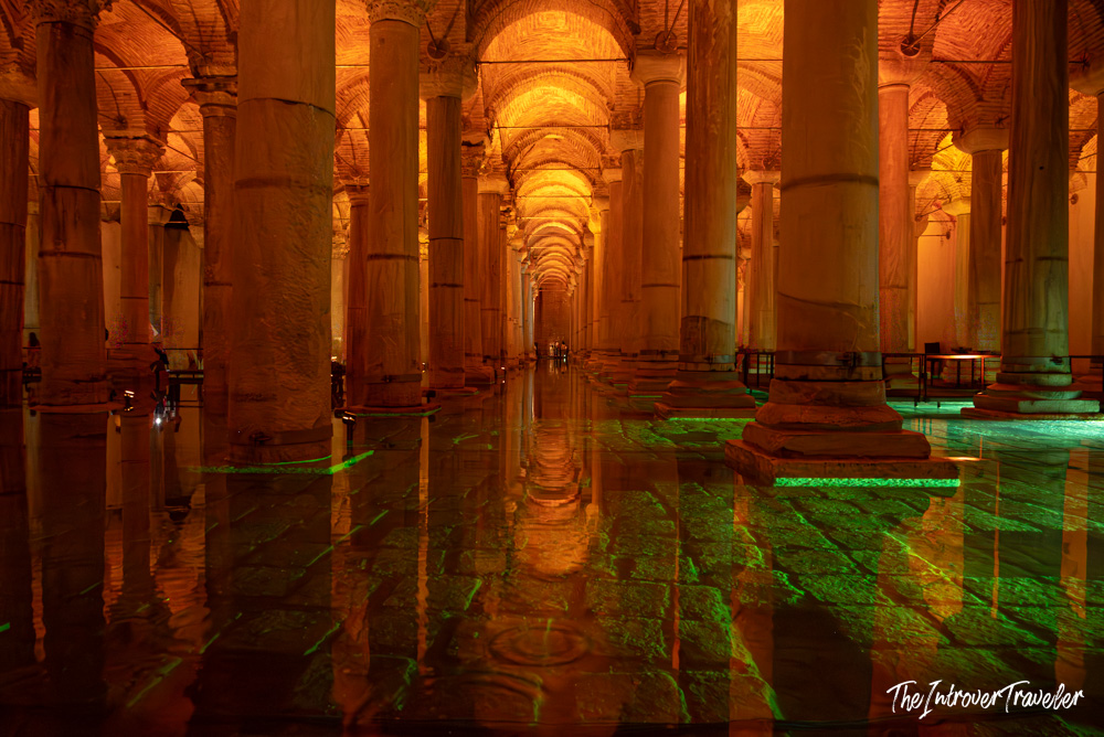 Interior of the Basilica Cistern in Istanbul, with marble columns, arched ceilings, and green light reflections on the wet floor