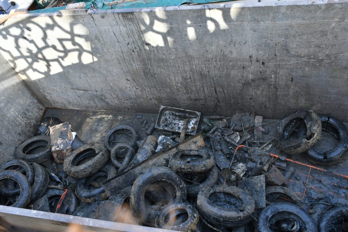 Mud-covered tires and scrap metal recovered from Venice canal floors by volunteer divers