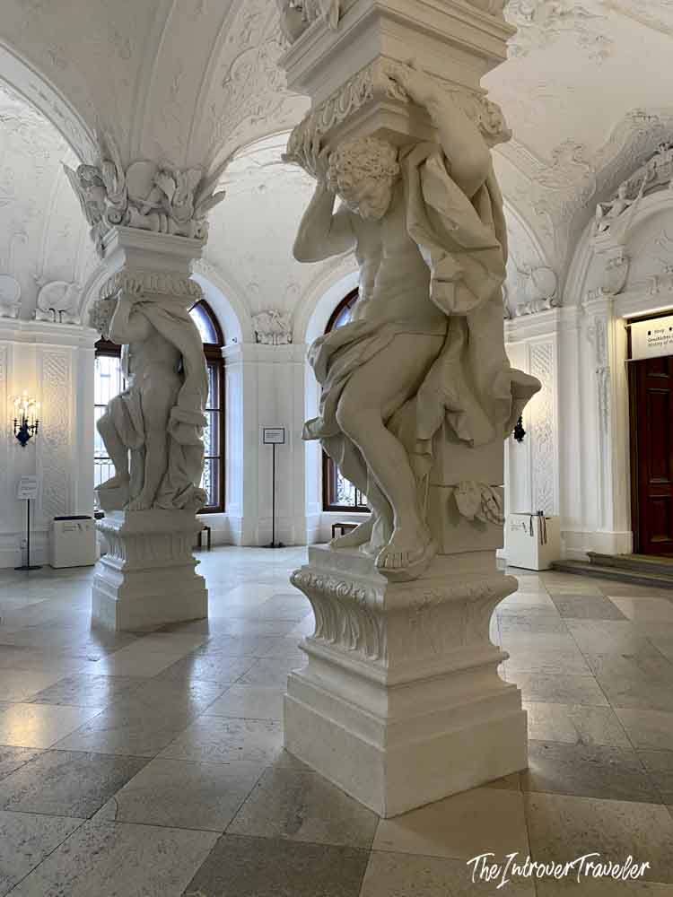 Baroque atlante figures supporting ornate columns in the grand entrance hall of Belvedere Palace, Vienna