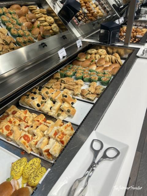 Buffet spread of savory pastries and finger sandwiches at Leonardo Lounge, Milan Linate Airport
