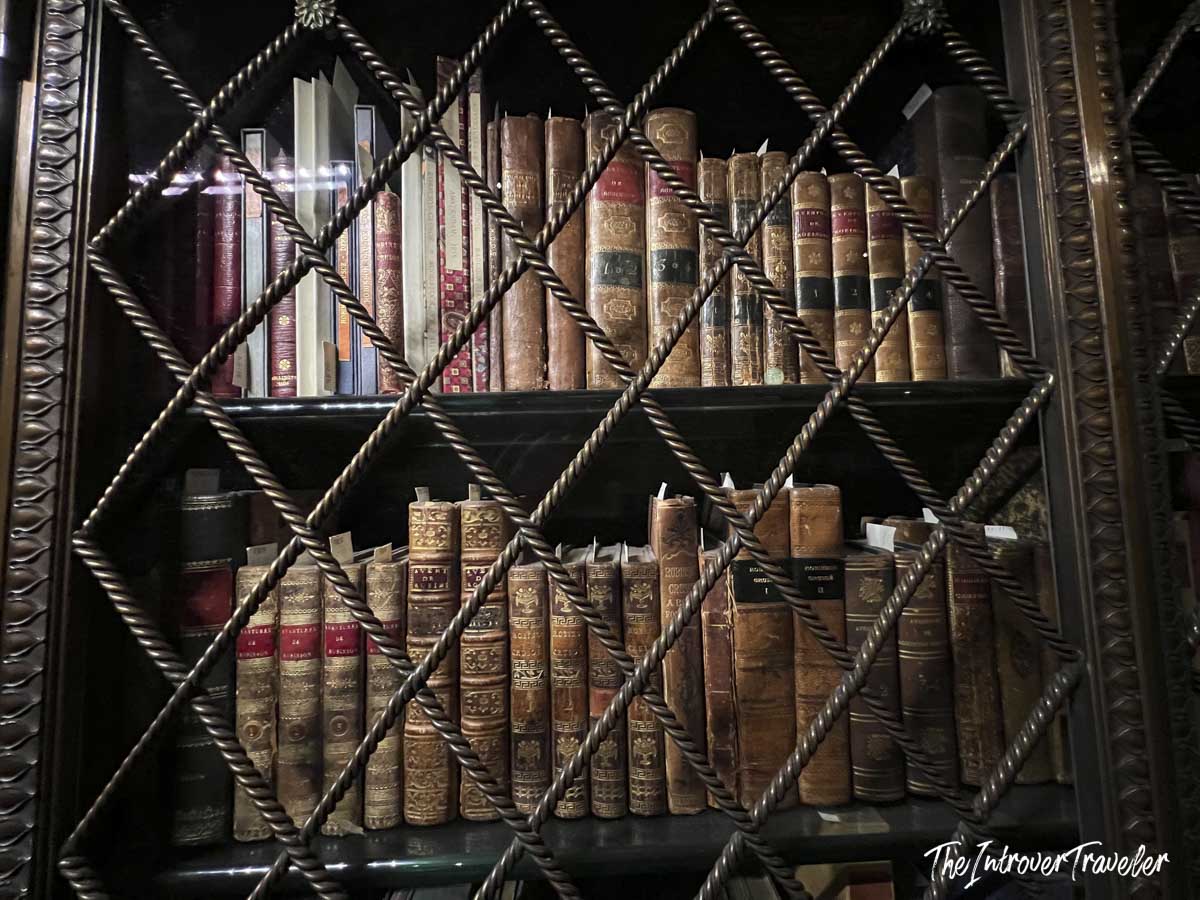 Antique leather-bound books behind ornate latticed cabinet doors at the Morgan Library, New York