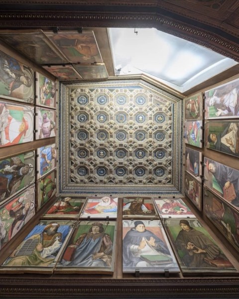 Upward view of the Studiolo of Federico da Montefeltro, showing painted panels and ornate coffered ceiling in Urbino