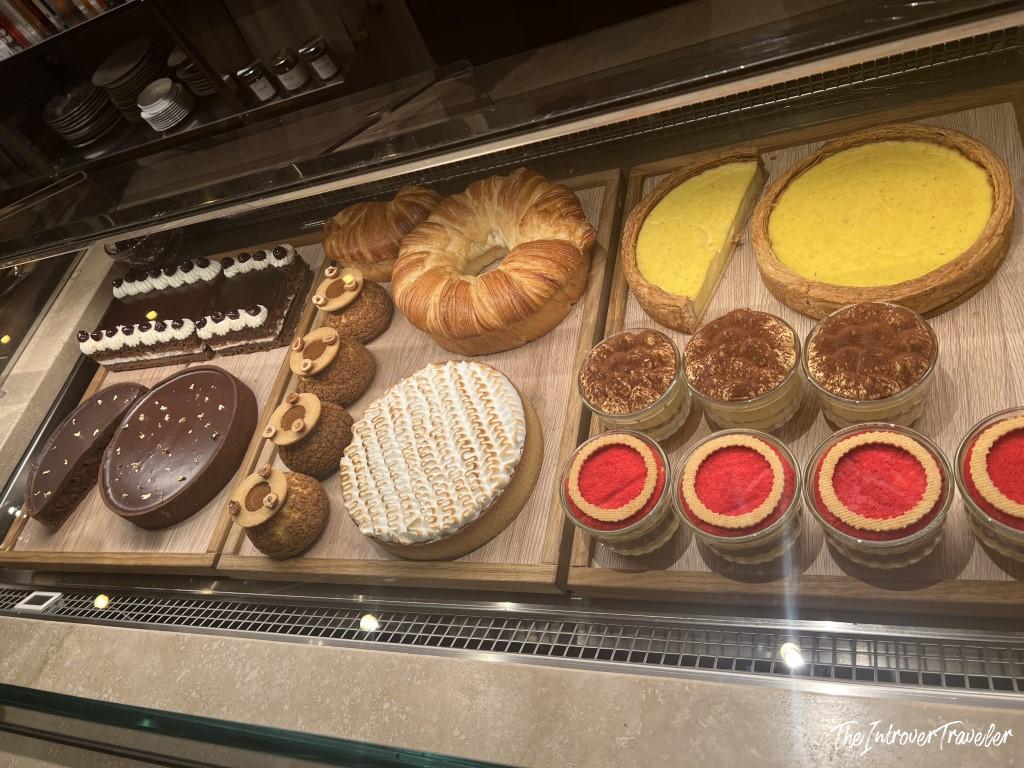 Dessert display case at Trattoria Da Lucio in Rimini, with tiramisu, tarts, and pastries