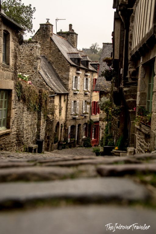 Cobblestone street lined with medieval stone houses in Dinan, Brittany, France