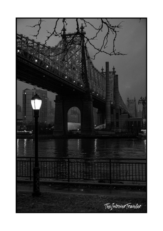 Queensboro Bridge at dusk, black and white street photo from the East River waterfront, New York