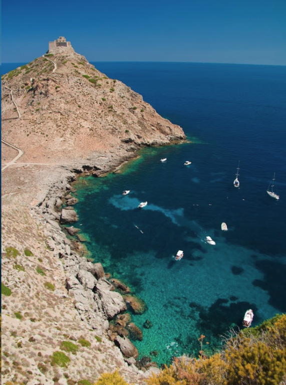 Aerial view of Marettimo rocky coastline, Egadi Islands, with turquoise waters and a hilltop fortress