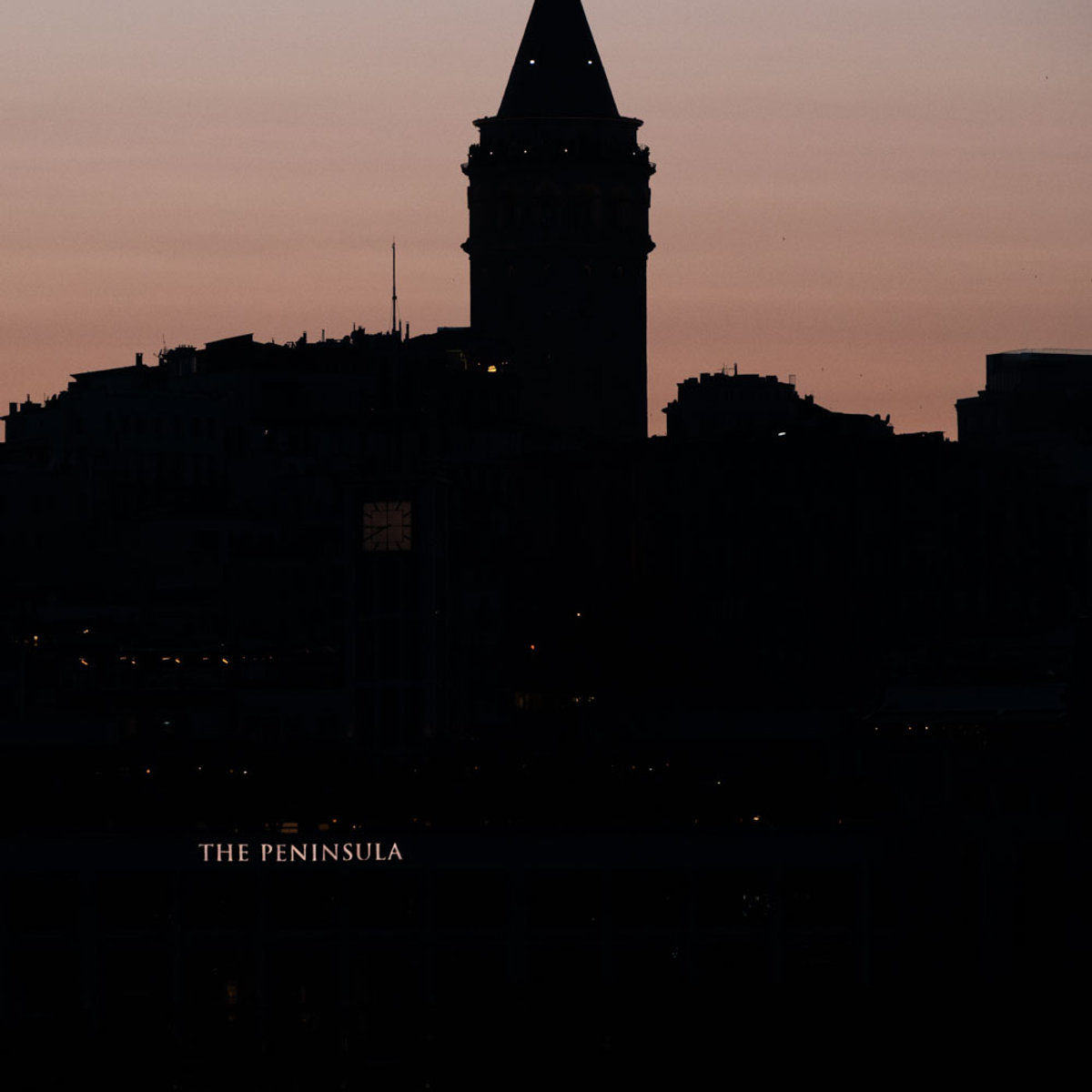 Galata Tower silhouette against a pink dusk sky, viewed from The Peninsula Istanbul
