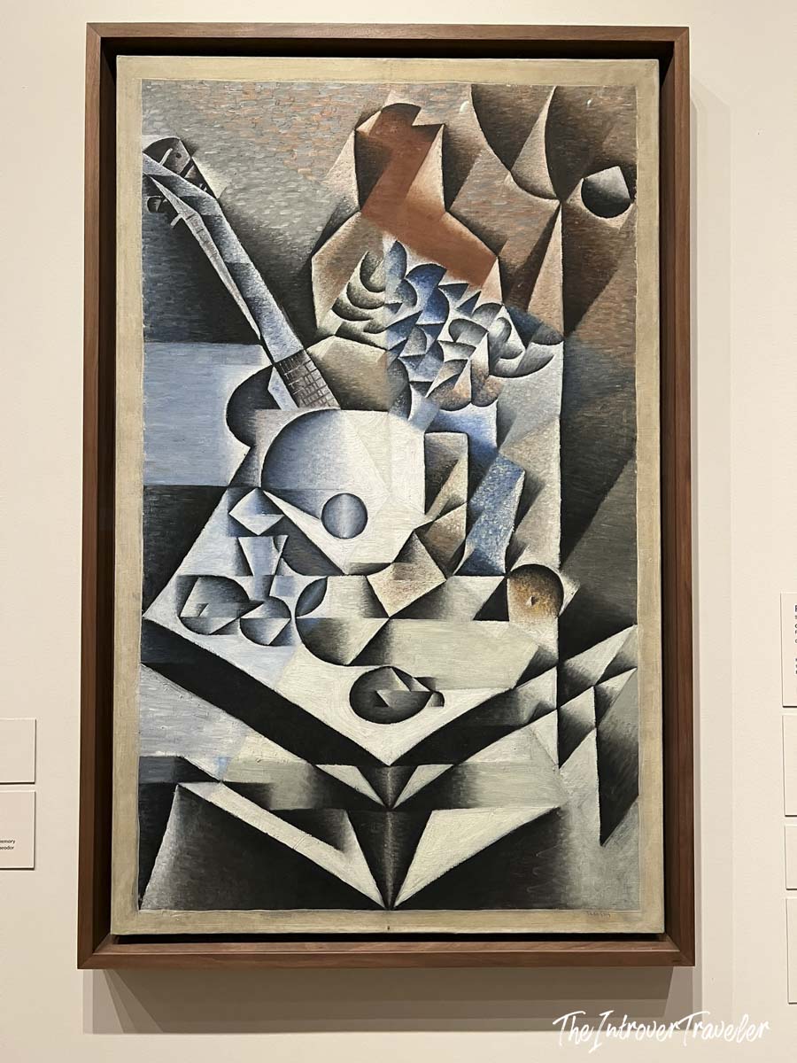 Cubist still life painting with guitar and fruit by Juan Gris, on display at MoMA New York
