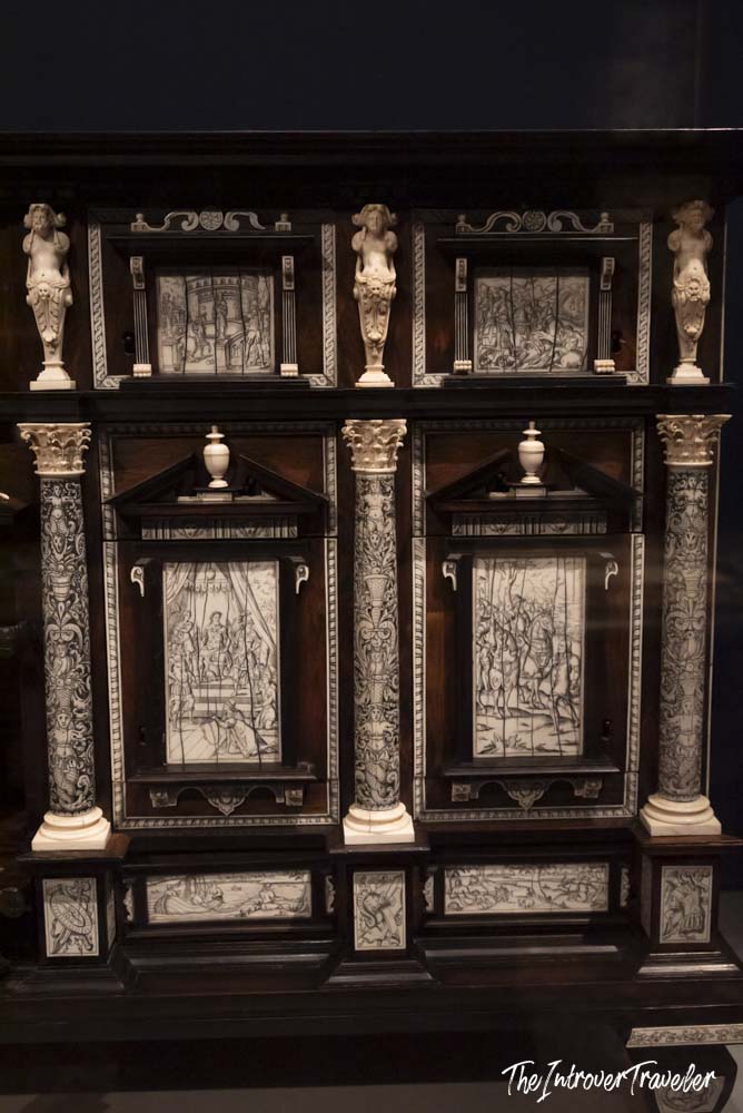 Ornate ebony cabinet with ivory carvings and figurines on display at the Metropolitan Museum of Art