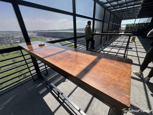 Open terrace of the IGA Lounge at Istanbul Airport with wooden bar counter and panoramic city views