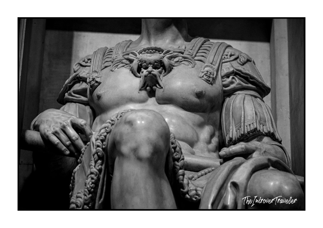 Close-up of Michelangelo's Giuliano de' Medici statue torso, showing ornate Roman armor detail in the New Sacristy