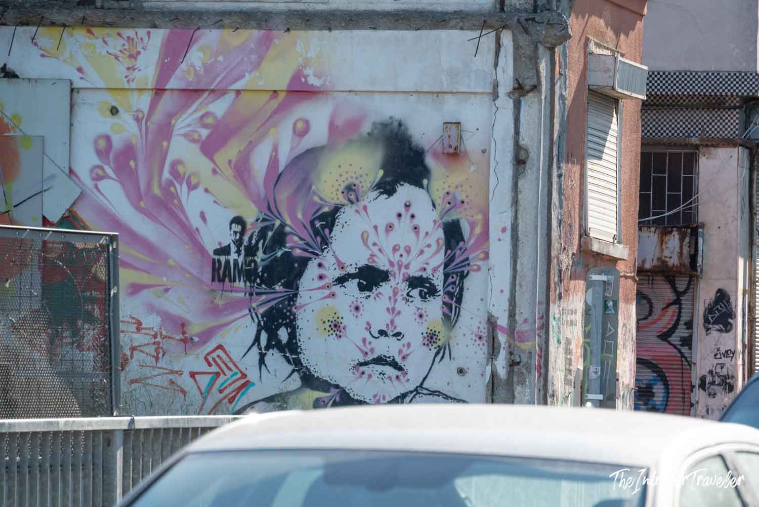 Kadıköy street art mural showing a stenciled face with pink floral bursts on a weathered Istanbul wall