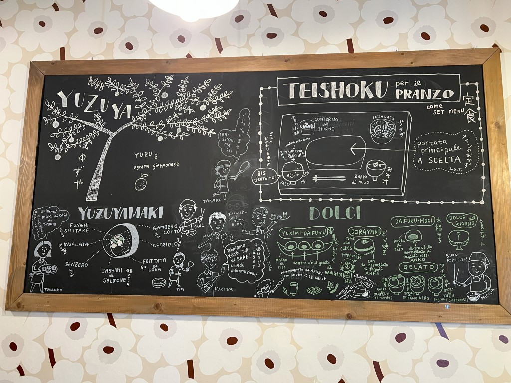 Yuzuya restaurant chalkboard menu in Bologna showing teishoku lunch sets and dolci in Italian and Japanese