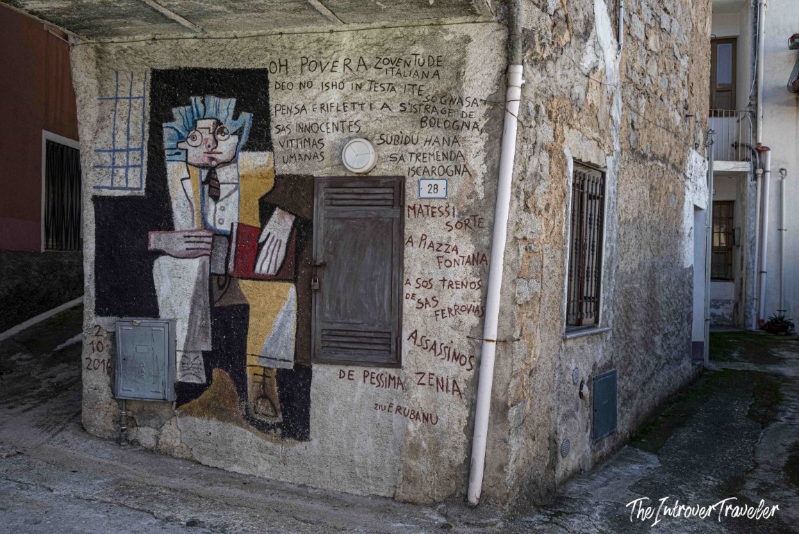 Political mural by Ziu E. Rubanu on a stone building in Orgosolo, Sardinia, referencing the Bologna massacre