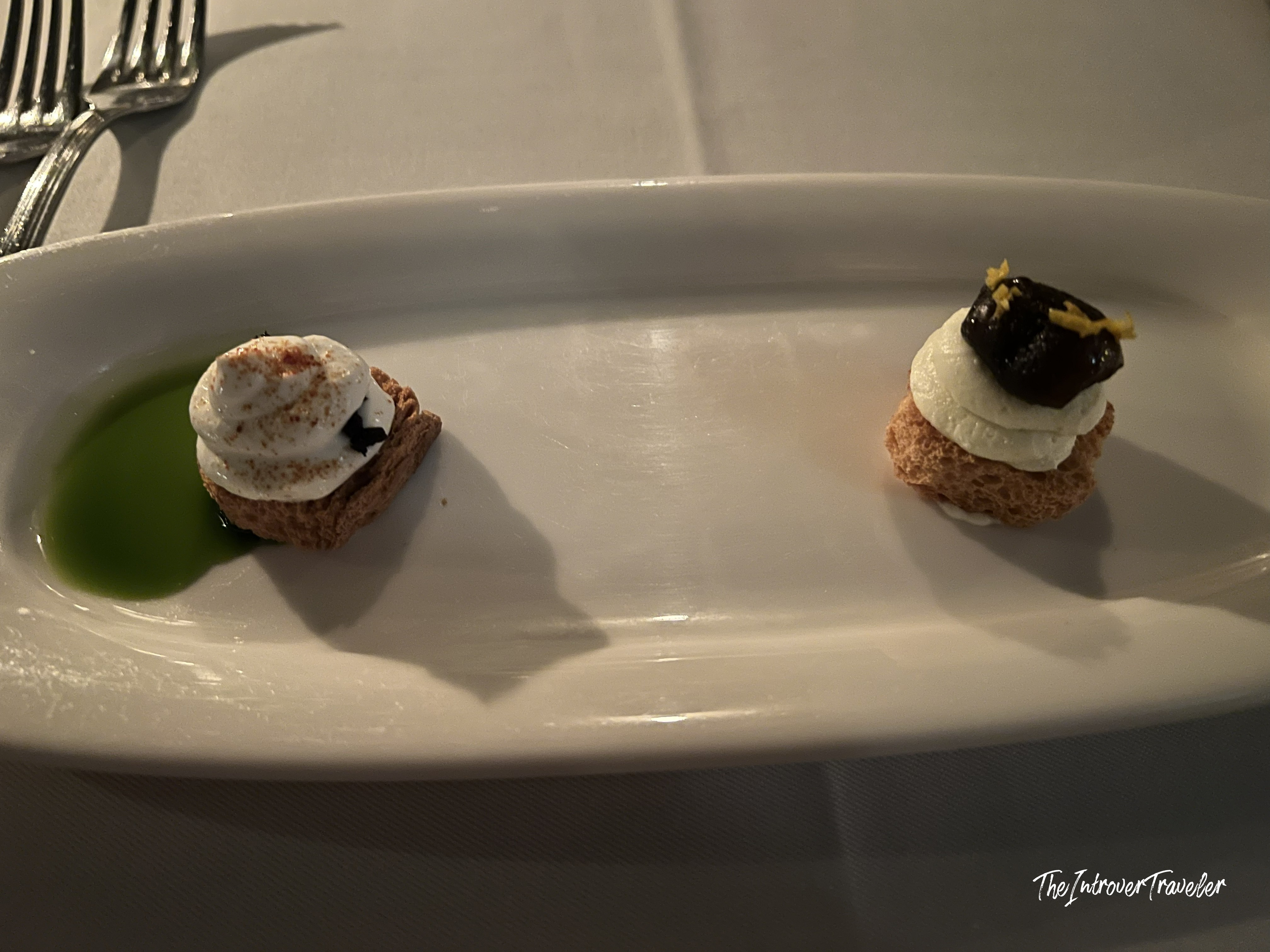 Two elegant amuse-bouche bites at Lokanta 1741, one with green herb oil and one topped with dark glaze.