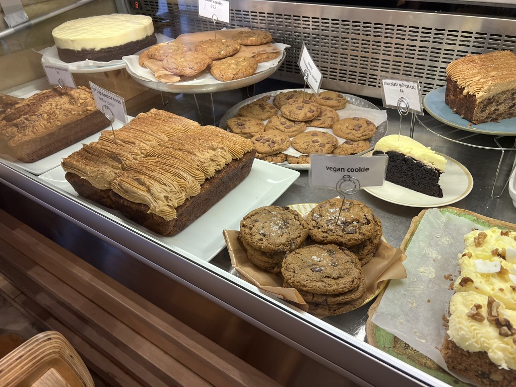 Bakery display case at Melaleuca Bistrot Florence, with vegan cookies, chocolate Guinness cake, and banana bread