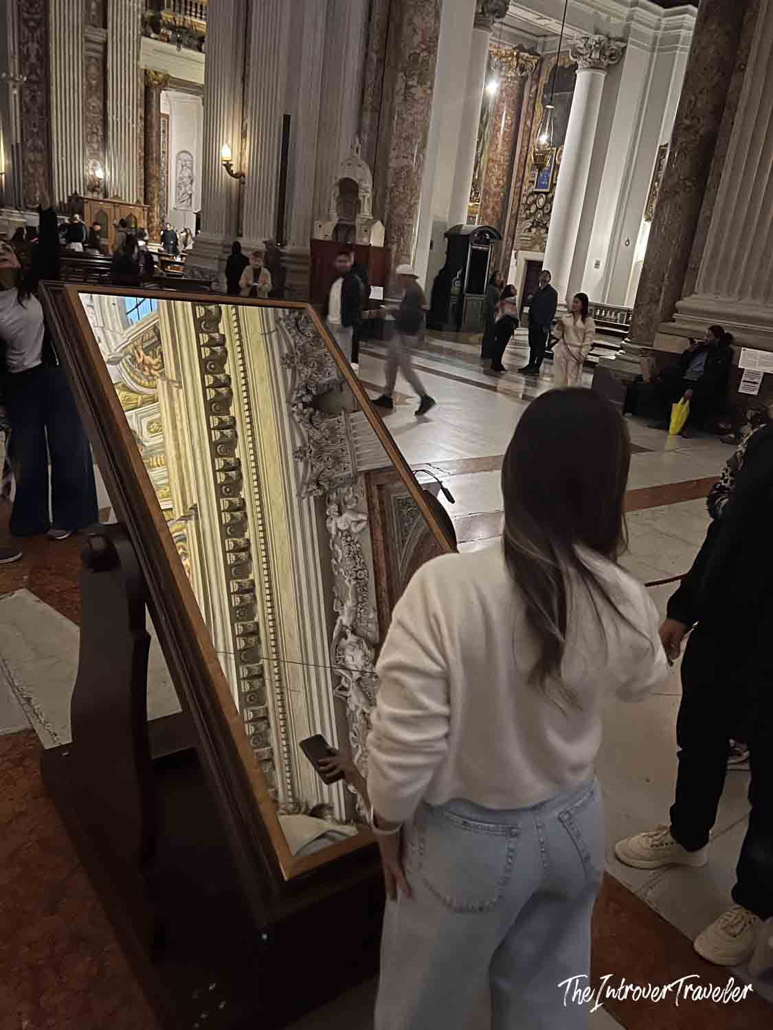 Visitor using a tilted mirror to view Andrea Pozzo's trompe l'oeil ceiling at Sant'Ignazio, Rome