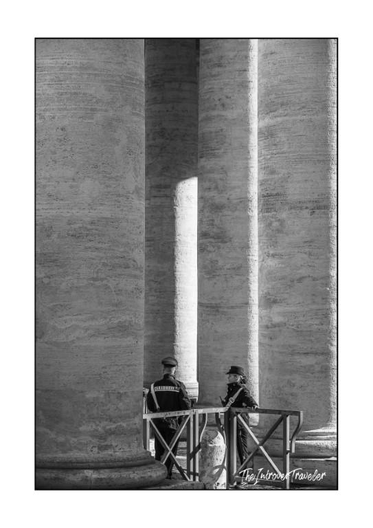 Carabinieri officer and visitor at a security checkpoint between Bernini's colonnade pillars, St. Peter's Square