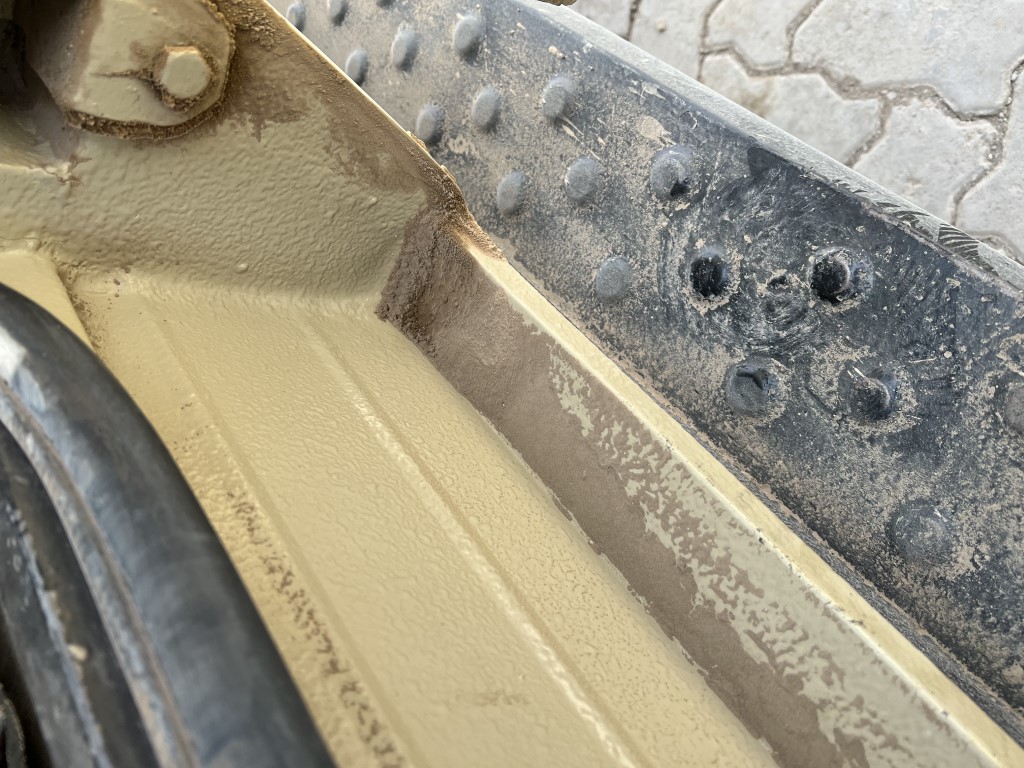 Close-up of a dusty safari vehicle step and chassis in Tanzania, showing off-road wear