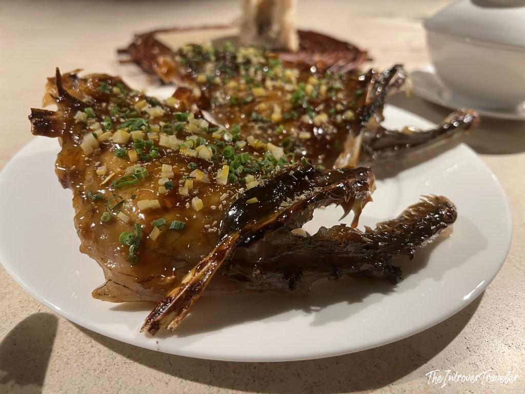 Glazed whole scorpionfish with ginger and spring onions, a signature seafood dish at Trattoria Da Lucio, Rimini