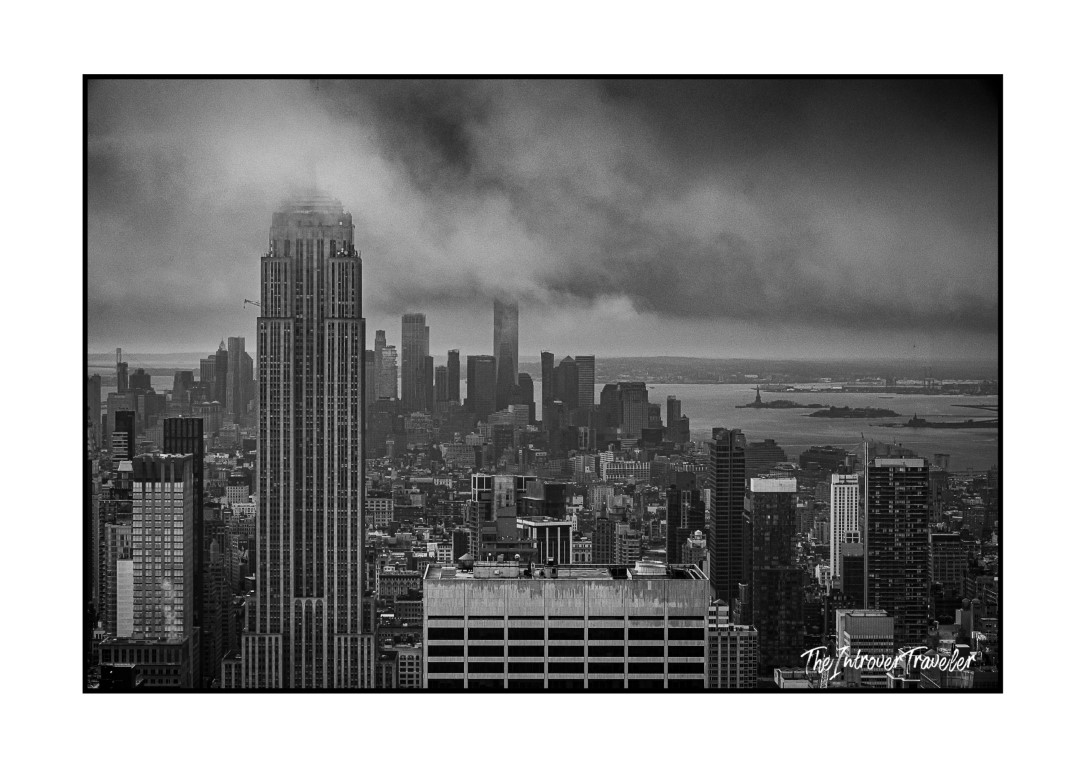 Black and white view from Top of the Rock, Empire State Building and Statue of Liberty in the distance