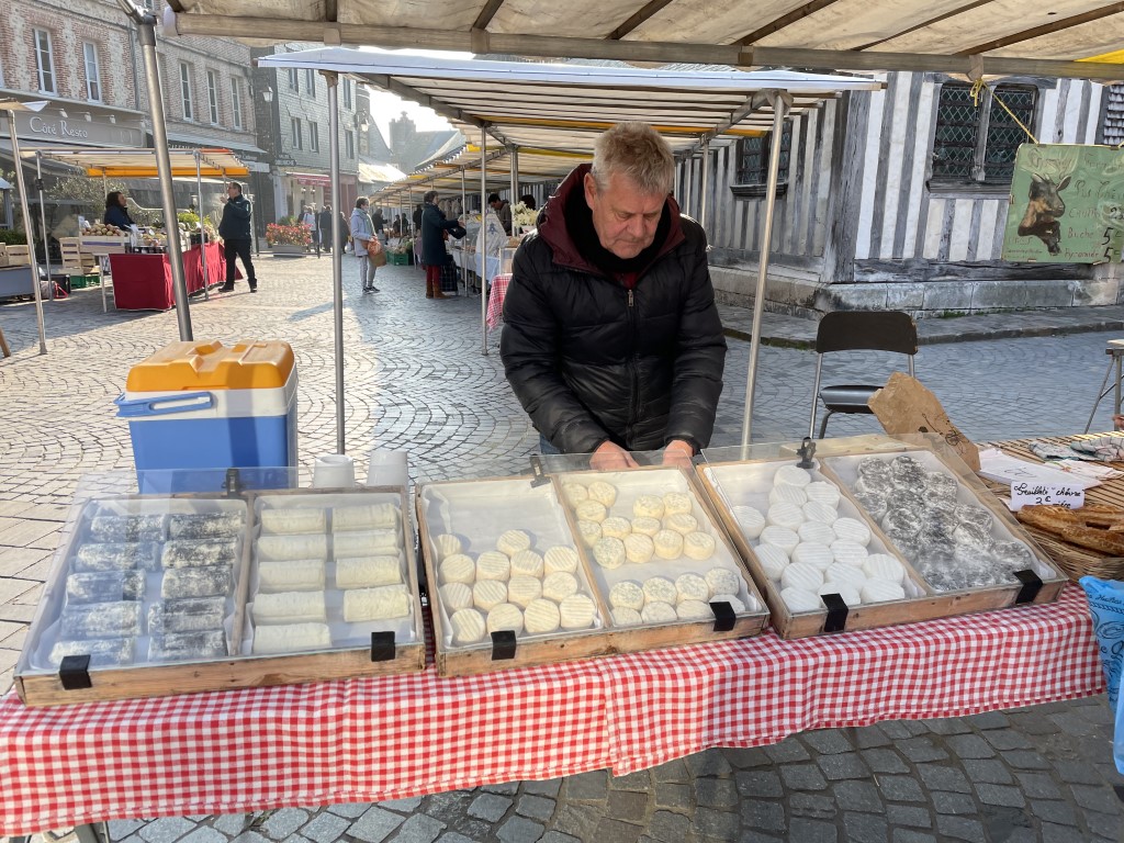 Cheese vendor selling fresh chèvre and local Norman cheeses at Honfleur Saturday market, Normandy
