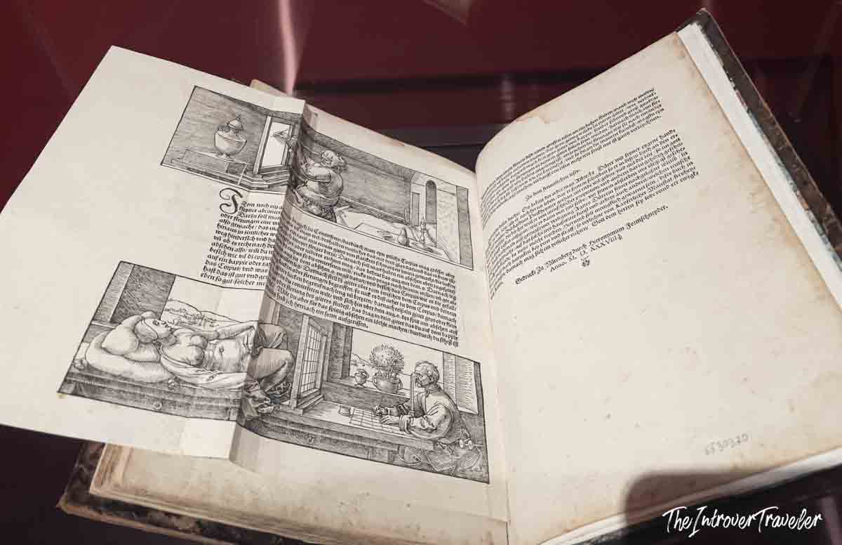 Open spread of Dürer's treatise on human proportion, featuring woodcut illustrations, displayed at the Accademia Gallery Venice
