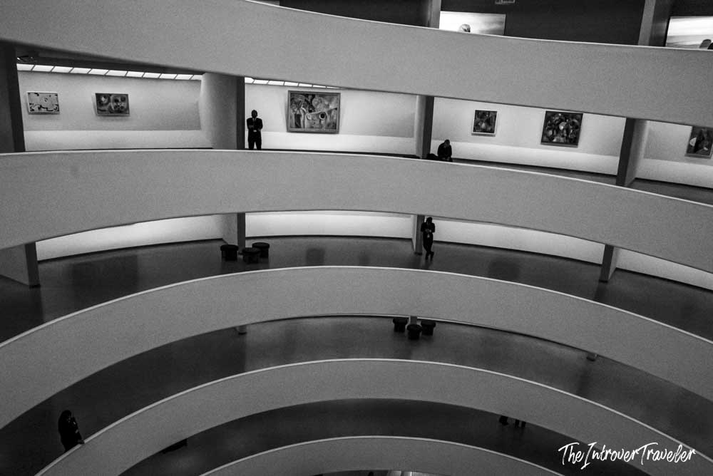 Guggenheim Museum New York interior, spiral ramps with visitors and art lining the curved gallery walls