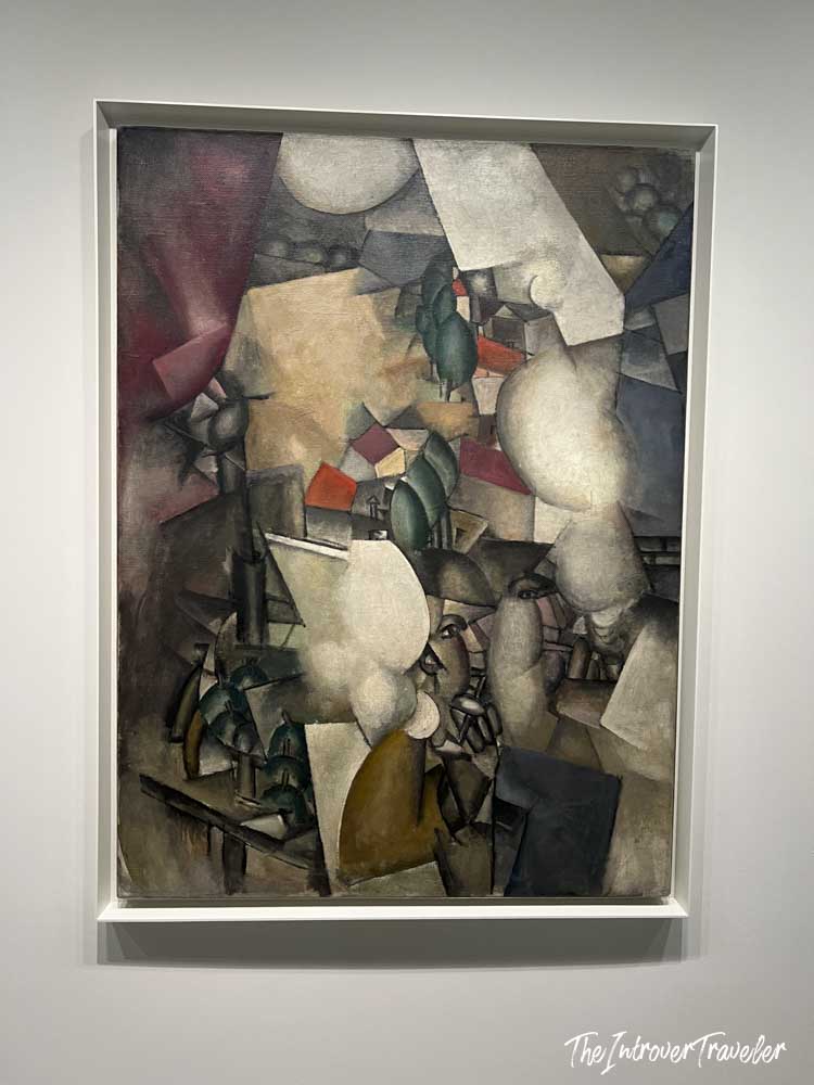 Cubist village landscape painting displayed on a white gallery wall at the Guggenheim Museum New York