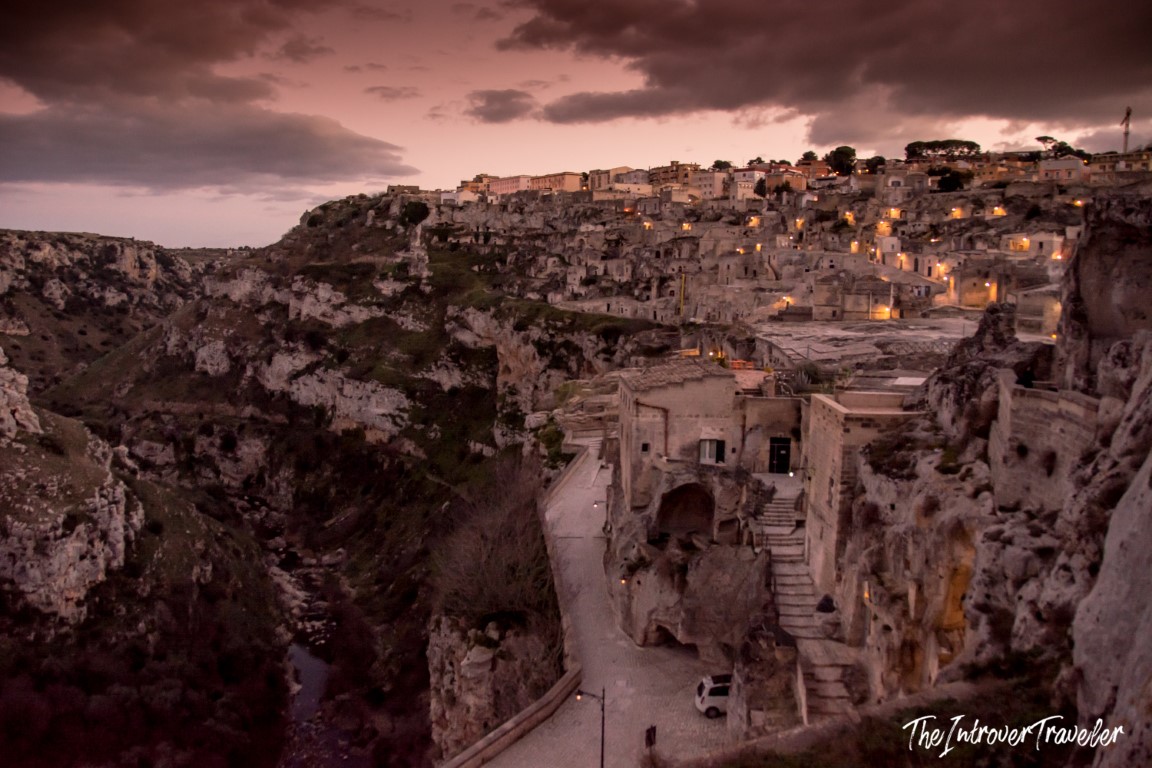 Matera Sassi cave dwellings glowing at dusk, carved into the ravine cliffs of Basilicata, Italy