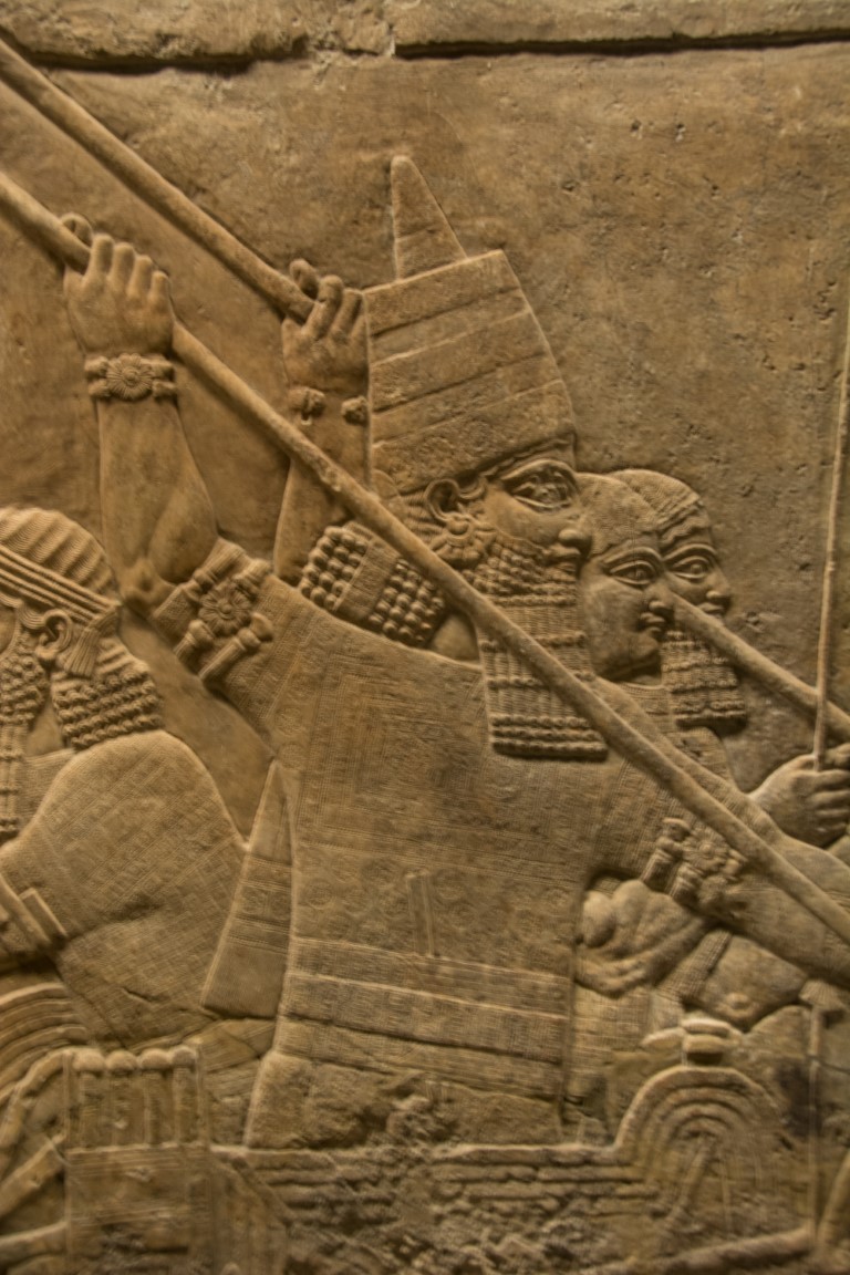 Ancient Assyrian stone relief at the British Museum, showing warriors with spears and pointed helmets