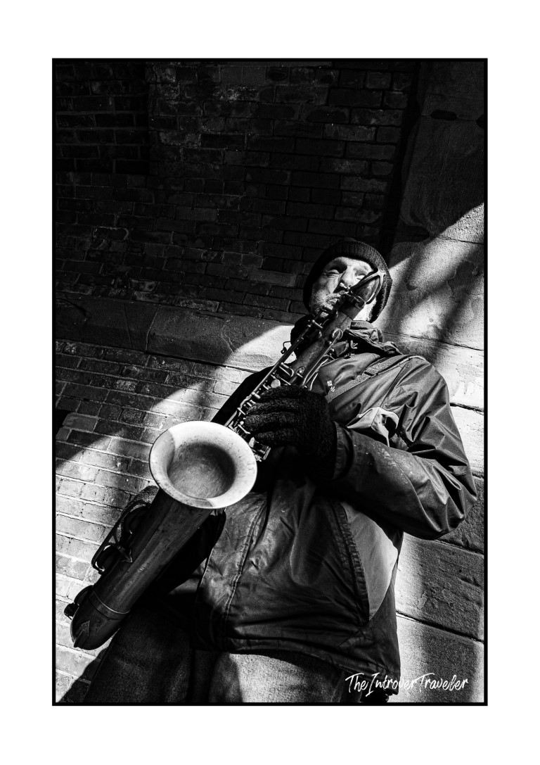 Street saxophonist busking near a brick wall in Central Park, New York City