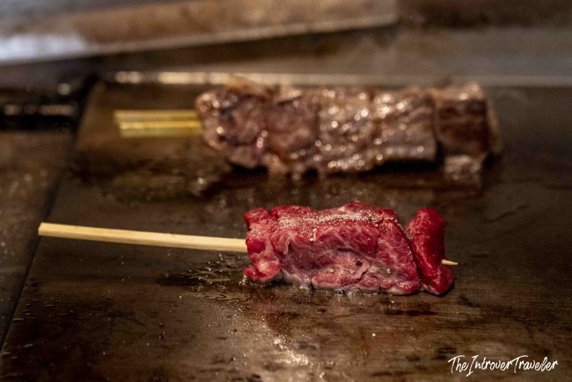 Wagyu beef skewer grilling on a teppan at Tsukiji outer market, Tokyo