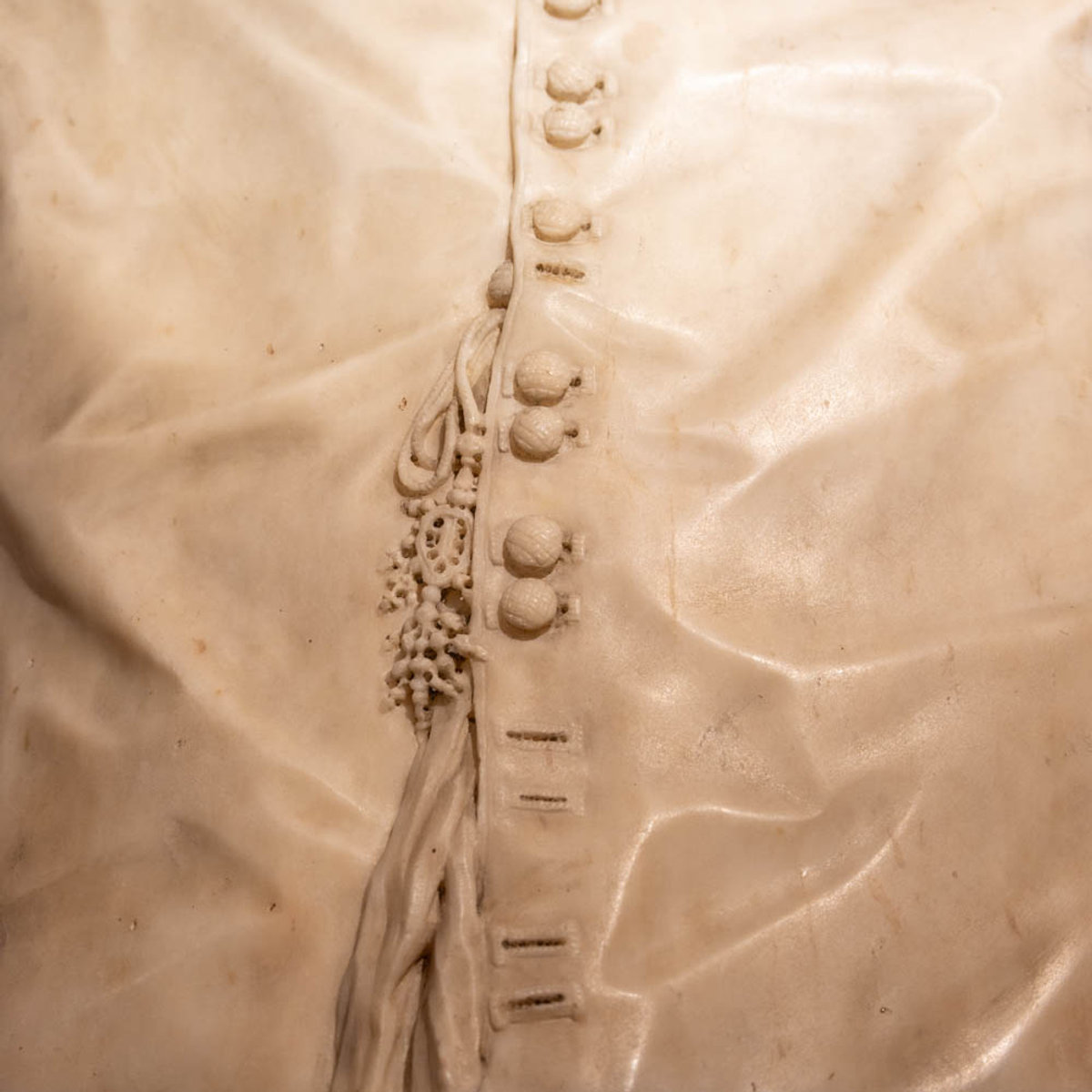Close-up of marble fabric folds and buttons carved by Bernini, showcasing his virtuoso technique at Palazzo Barberini