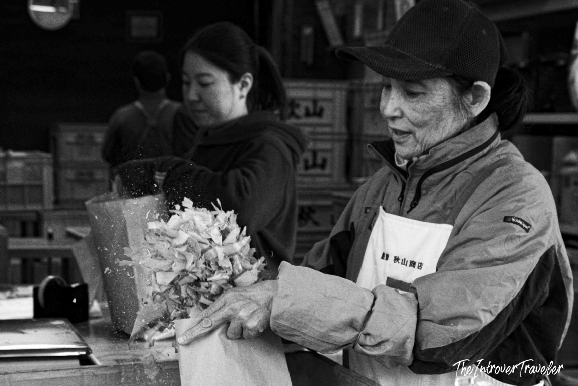 Elderly vendor packaging katsuobushi bonito flakes at Tsukiji fish market, Tokyo