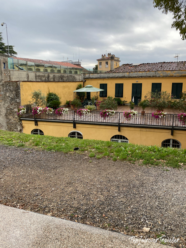 Yellow ochre building with flower-lined terrace viewed from Lucca's Renaissance city walls, Tuscany