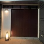 Unmarked wooden entrance door to Nishi Azabu Kamikura, a hidden omakase restaurant in Tokyo