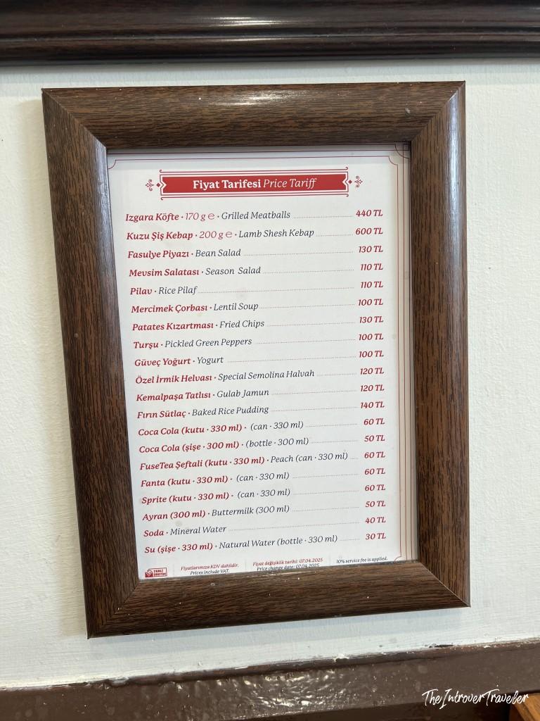 Framed price tariff menu at Sultanahmet Koftecisi, listing kofte, kebab, and Turkish sides in TL