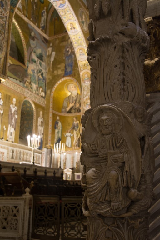 Carved column detail with saint figure inside the Palatine Chapel, Palermo, with golden Byzantine mosaics behind