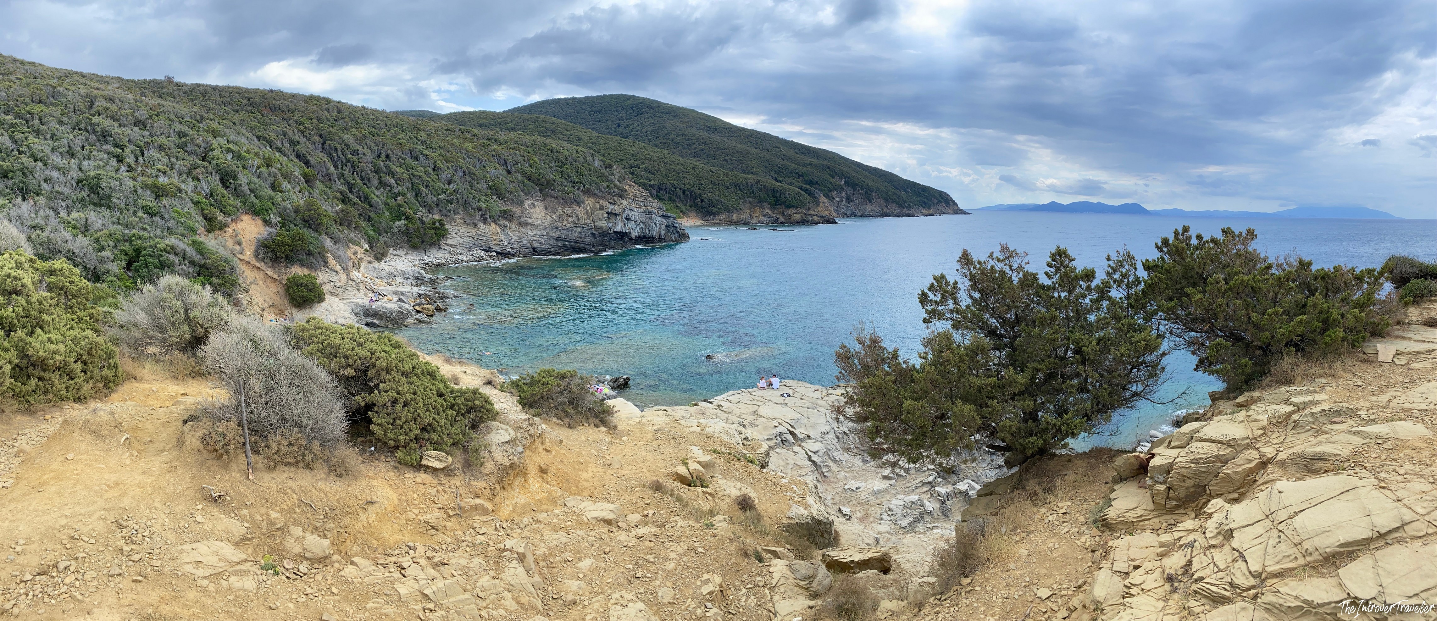 Panoramic view of Buca delle Fate cove, a rocky inlet near Populonia with turquoise water and forested hills
