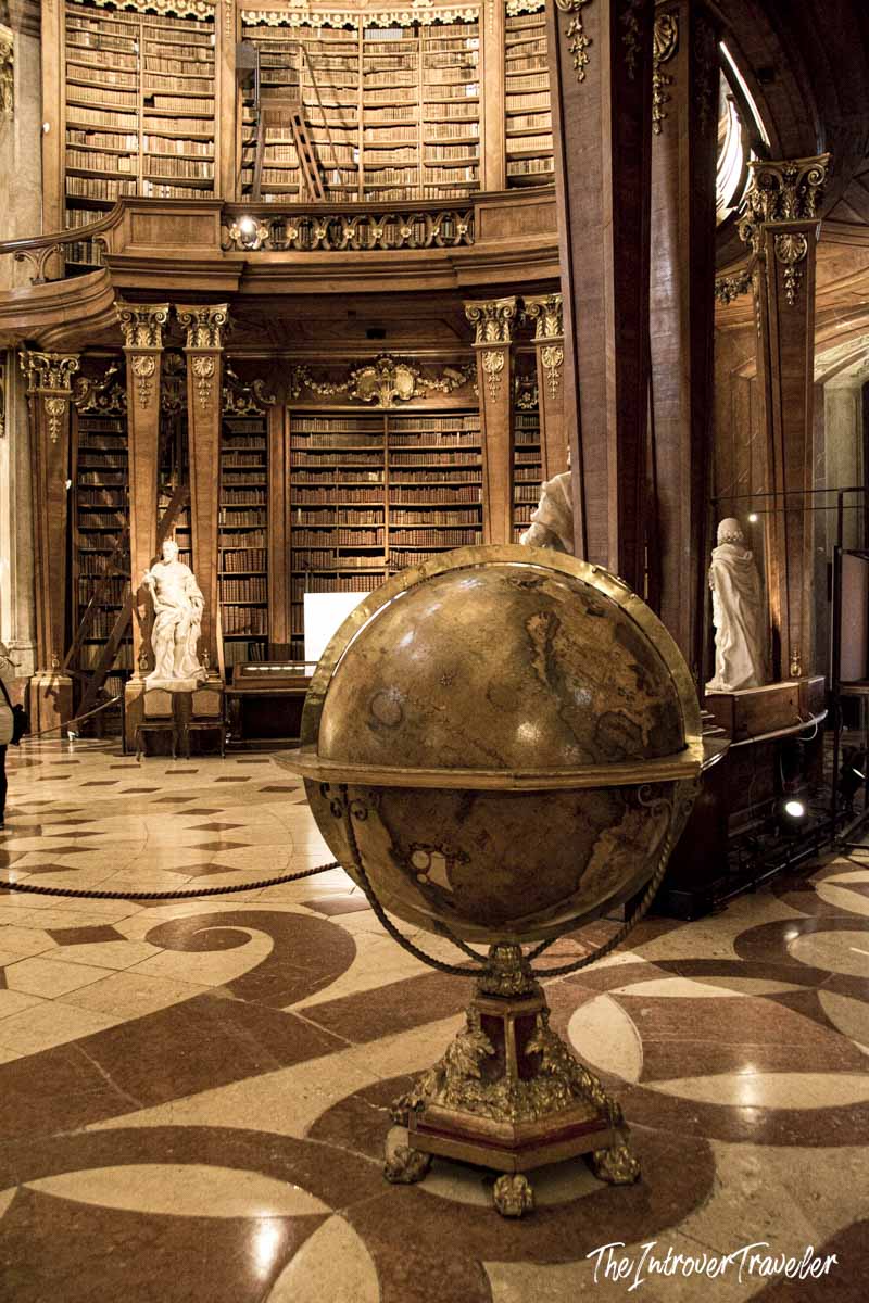 Antique terrestrial globe on ornate stand inside the Austrian National Library State Hall, Vienna